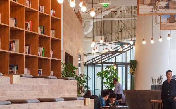 A man is standing in a room with bookshelves, highlighting the hospitality of the space.