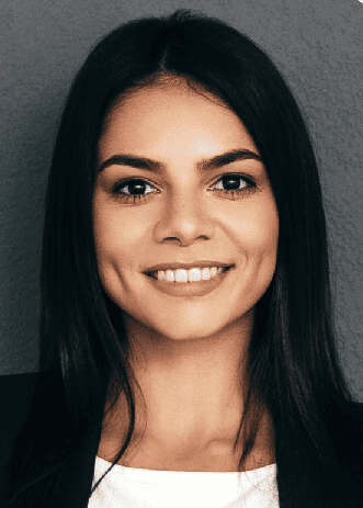 A woman in a black blazer and white shirt smiling, representing the best outsourcing solutions.