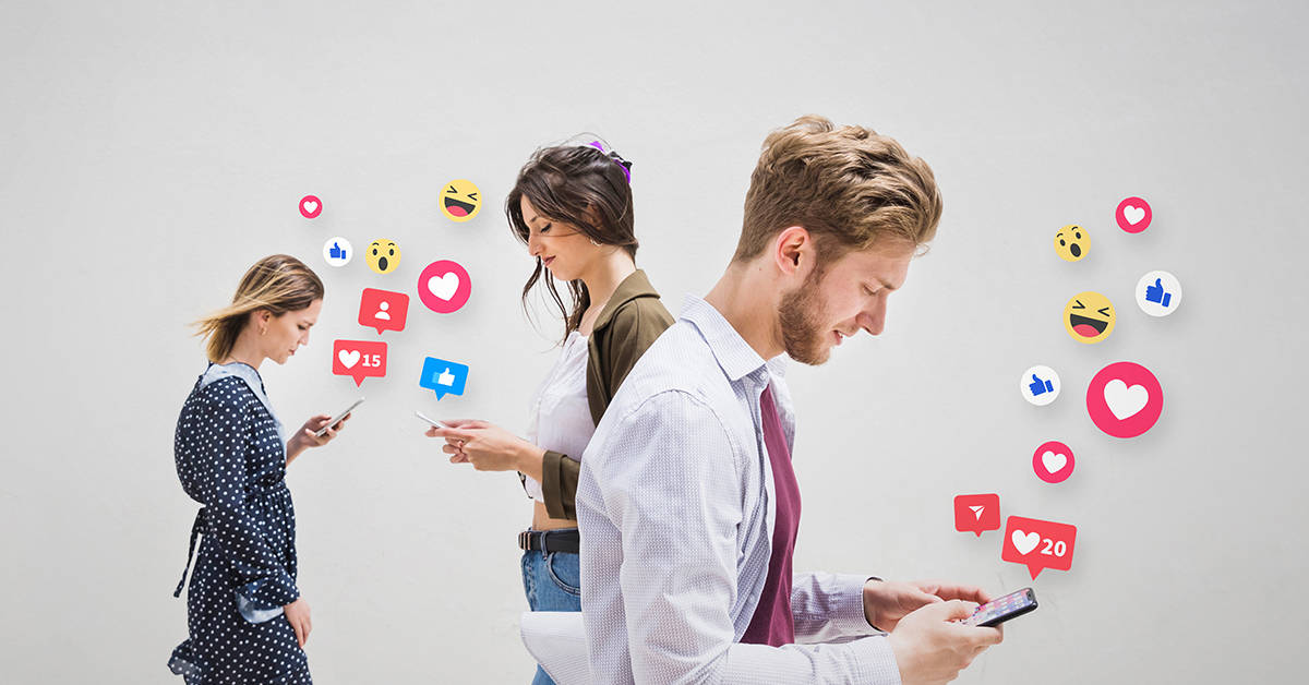 A group of people standing in front of a wall with social media icons.